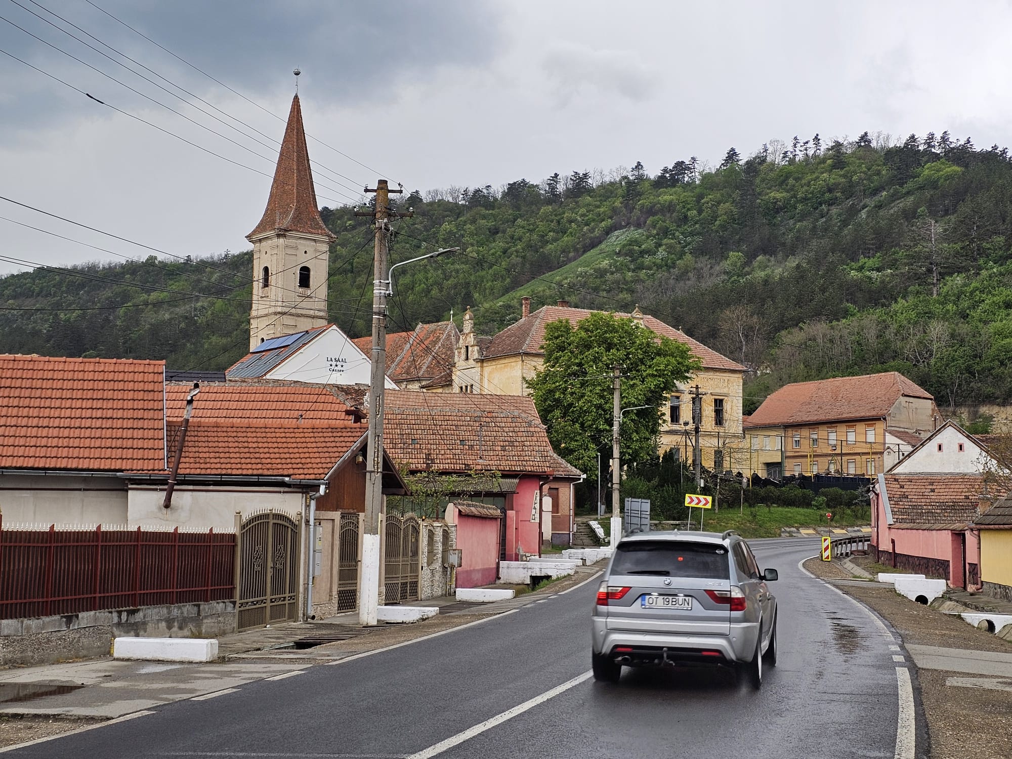 Vedere de pe stradă spre clădirea La Saal, cu turnul bisericii în fundal