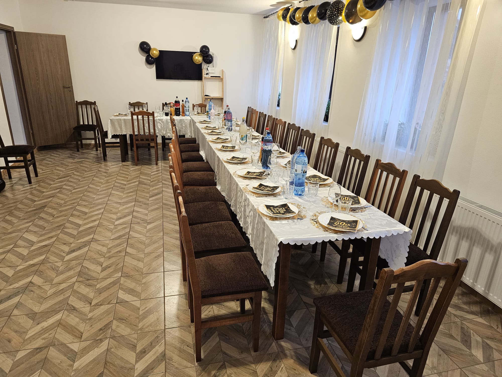 Masă festivă pentru o aniversare, farfurii aurii și baloane