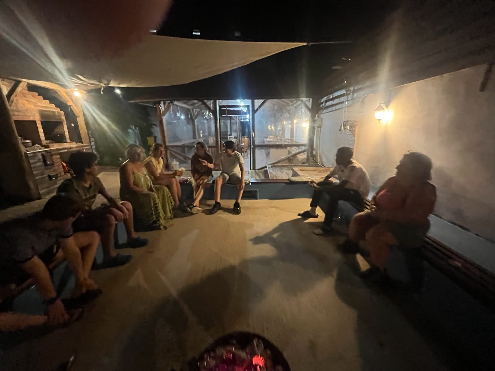 Oaspeți relaxați lângă foișor, seara